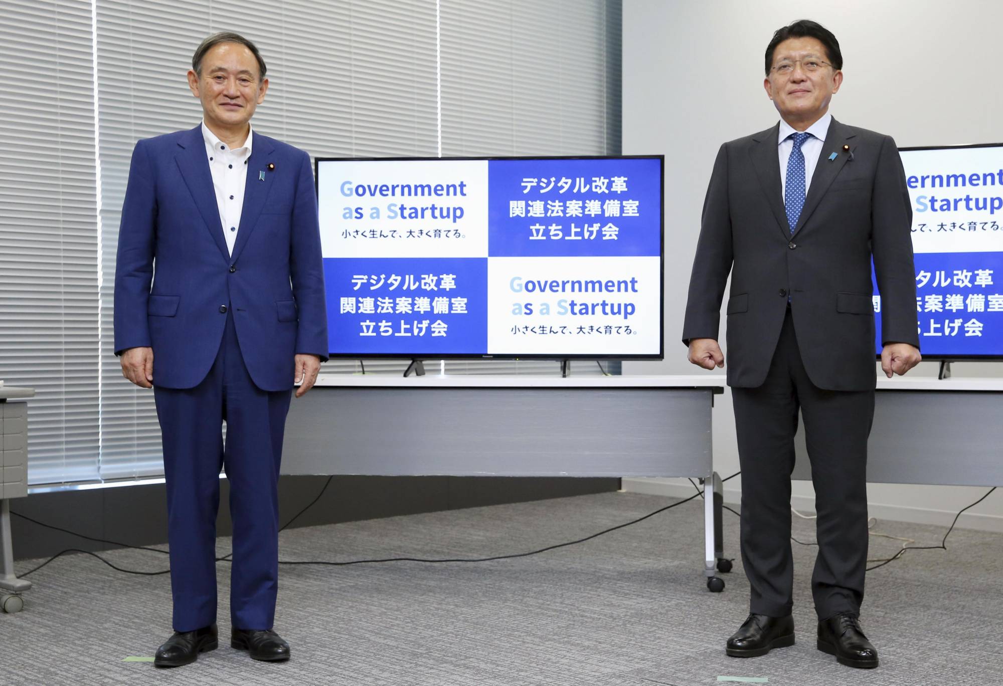 Prime Minister Yoshihide Suga (left) and digital reform minister Takuya Hirai launched an office established by the Cabinet Office and tasked with creating a digital agency, on Sept. 30. | POOL / VIA KYODO